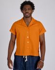 isaac is wearing Pantry Button-Up in Creamsicle Orange