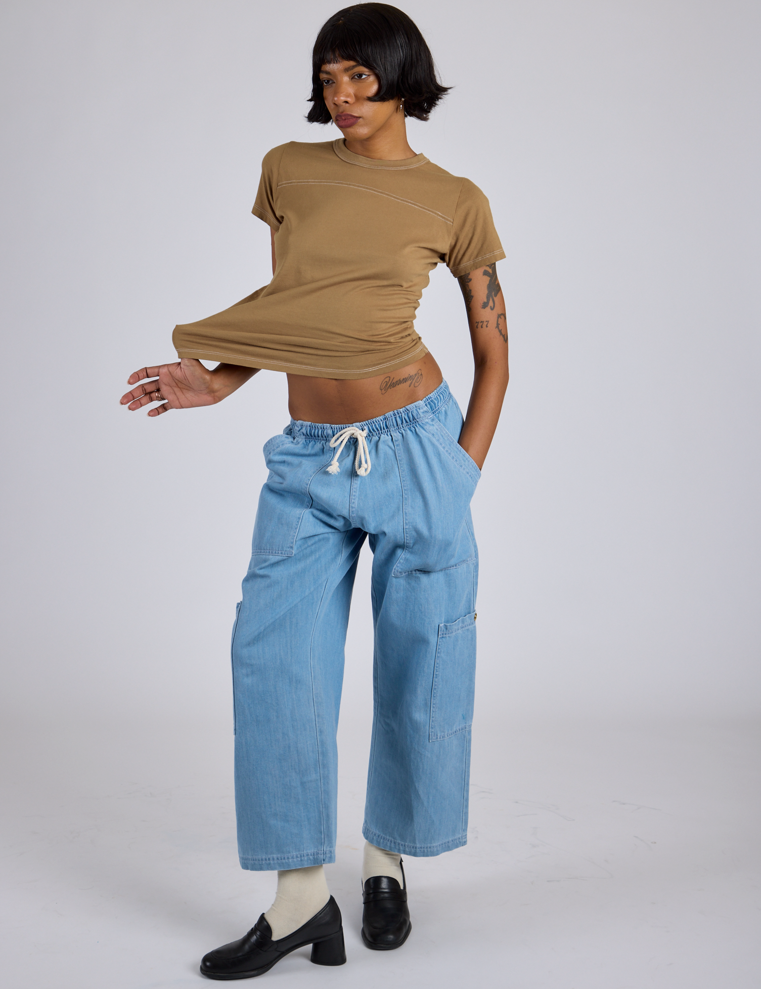 Kira is wearing Jr. Varsity Tee in Desert Brown and light wash Denim Drop Pocket Pants