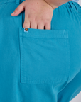 Close up of Juliet's hand in the back pocket of Longline Work Shorts in Hawaiian Blue