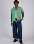 Isaac is wearing Pantry Button-Up in Seafoam Green and dark wash Drop Pocket Pants
