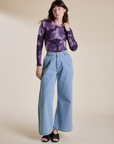 Alex is wearing Long Sleeve Baby Tee in Dark Lavender and light wash Wide Leg Trousers