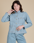 Alex is wearing a buttoned up Indigo Denim Work Jacket in Light Wash