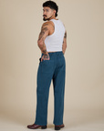 Angled back view of Work Pants in Lagoon and vintage tee white Cropped Tank on Jesse