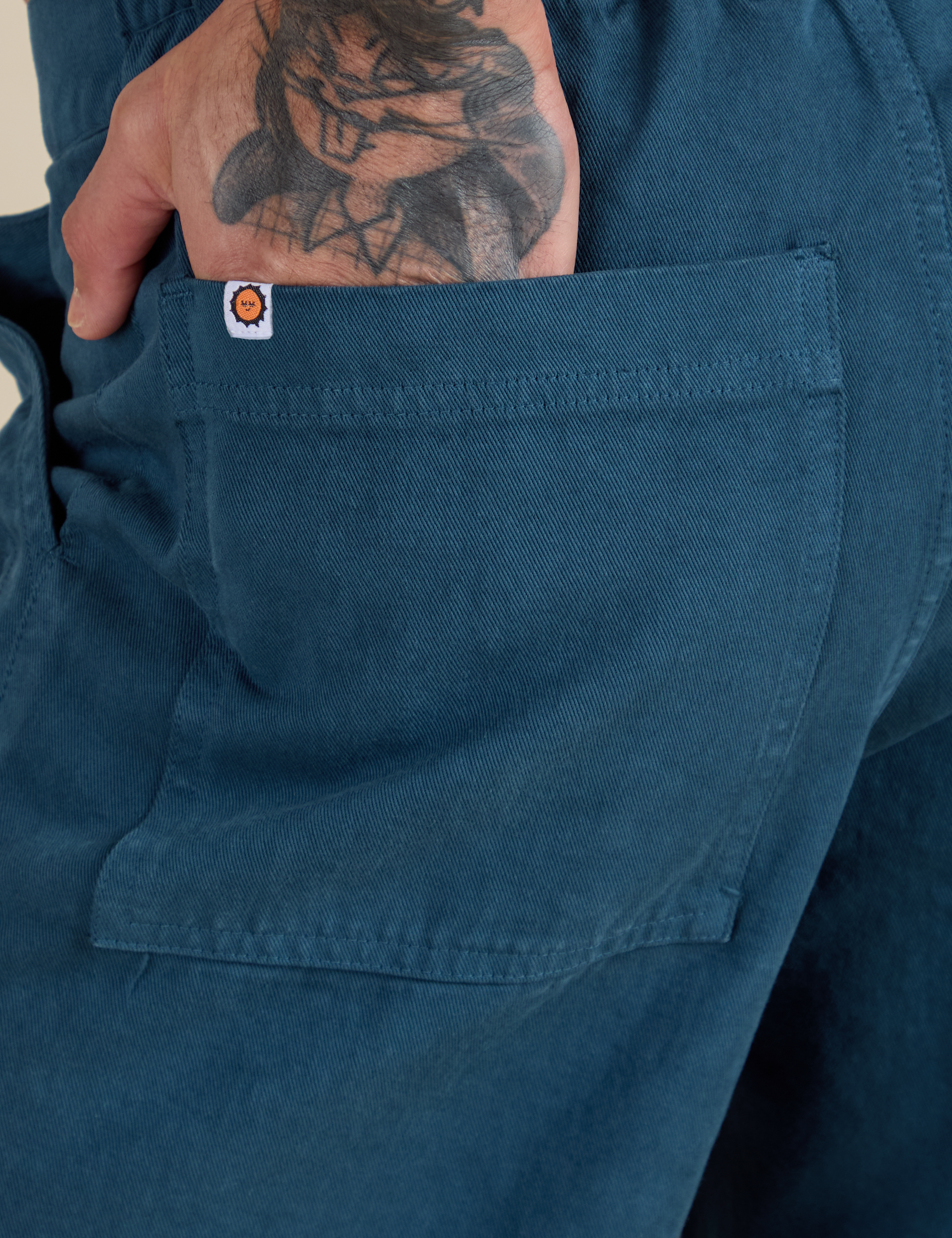 Close up of Jesse's hand in the back pocket of Work Pants in Lagoon