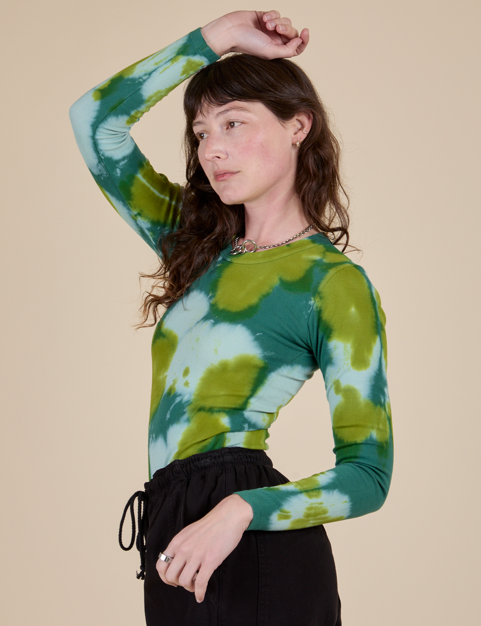 Long Sleeve Baby Tee in Green Magic Waters angled front view on Alex