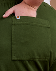 Close up of Juliet's hand in the back pocket of Organic Action Pants in Evergreen