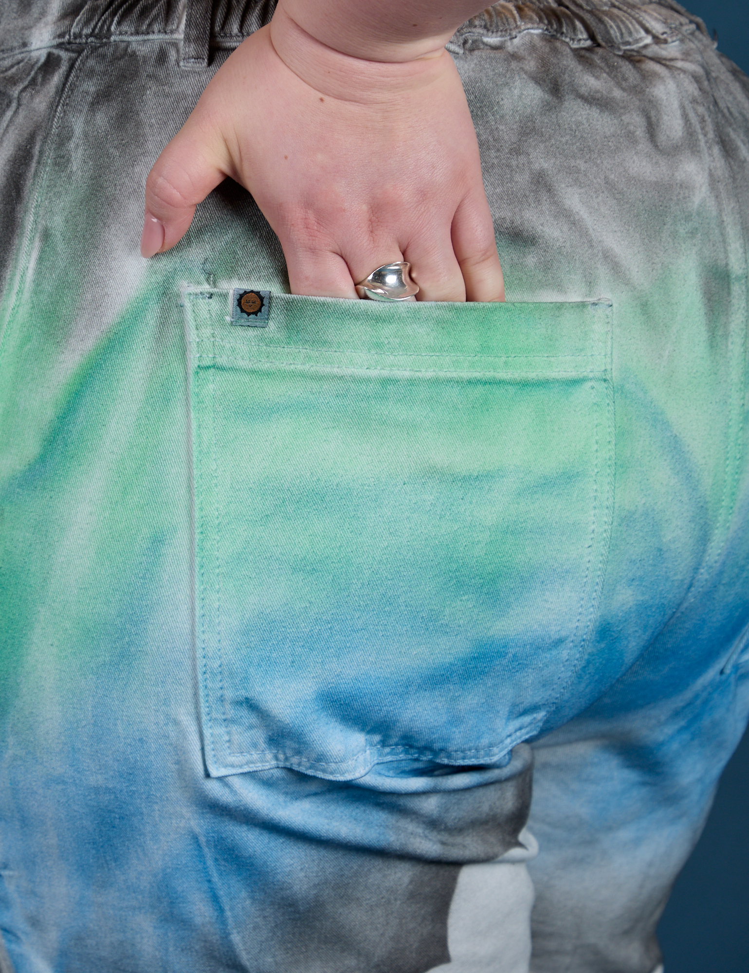 Close up of Ashley's hand in the back pocket of Work Pants in Night Sky Airbrush