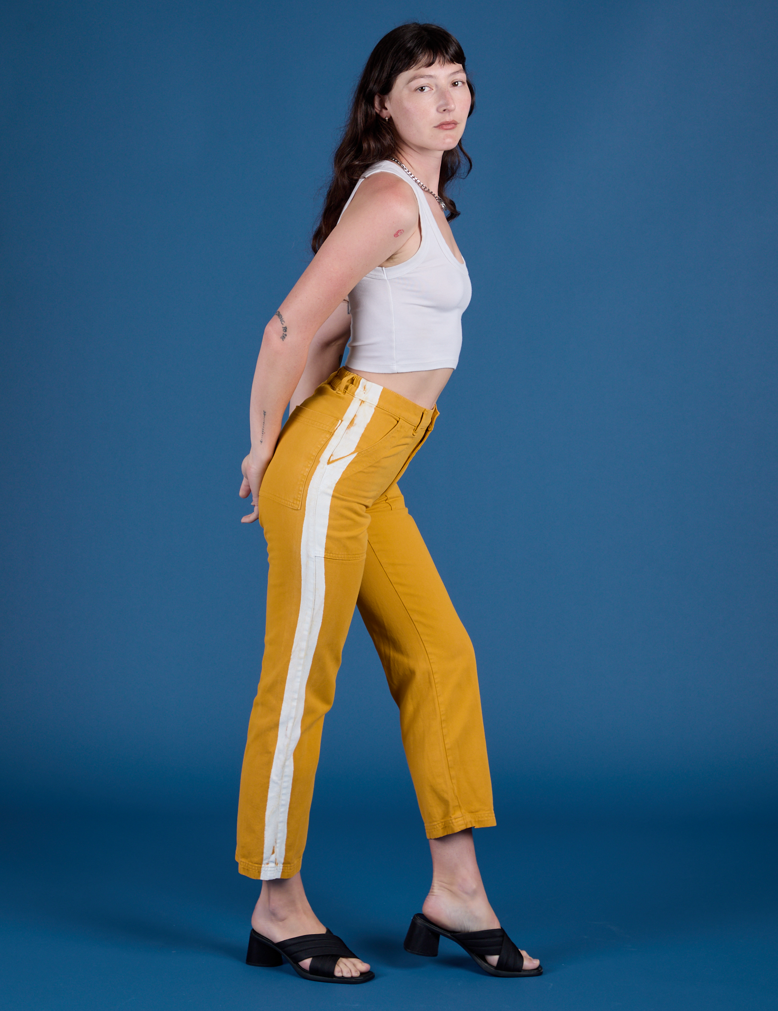 Side view of Painted Work Pants in Mustard Yellow and vintage tee white Cropped Tank