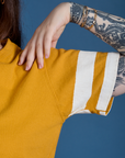 Painted Burly Tee in Mustard Yellow sleeve close up with two white painted stripes