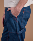 Close up of Quinn's hand in the front pocket of Carpenter Jeans in Dark Wash