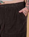 Close up of Sam's hand in the front pocket of Corduroy Drop Pocket Cargo Pants in Espresso Brown