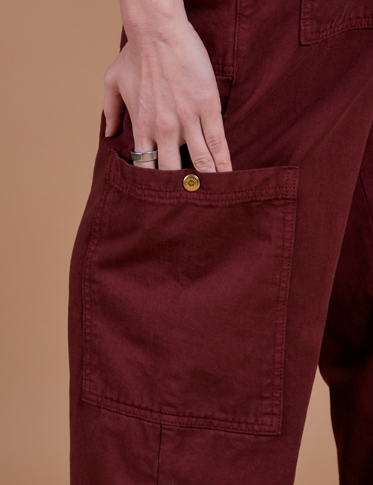 Close up of Alex's hand in the side pant leg pocket of Drop Pocket Cargo Pants in Red Wine