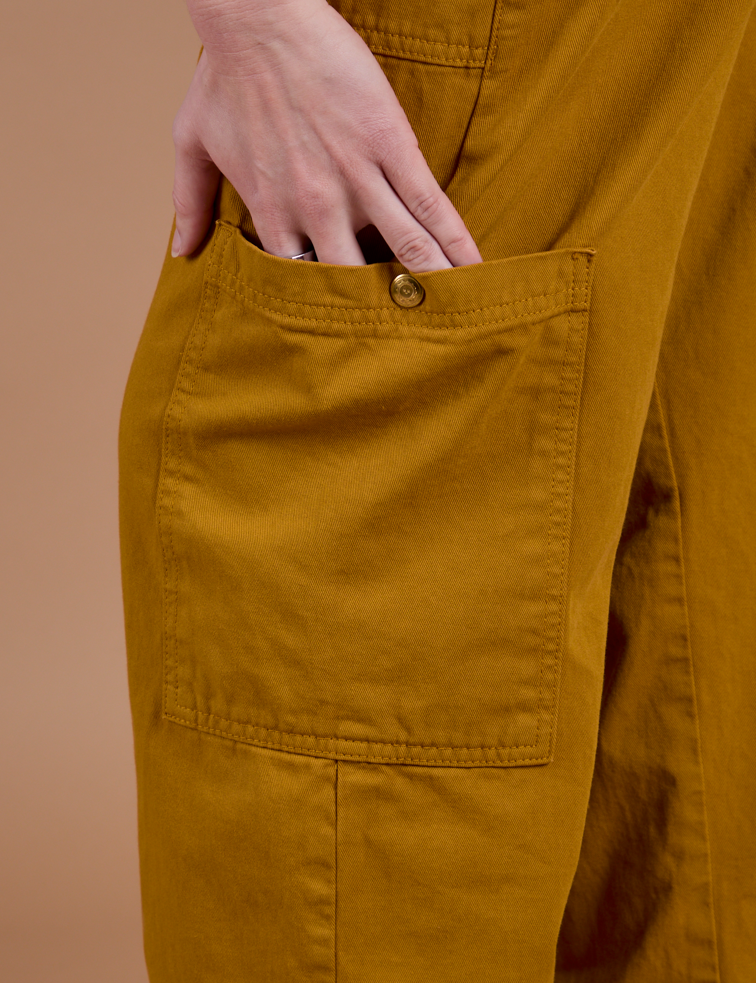 Drop Pocket Cargo Pants in Spicy Mustard pant leg pocket close up with Alex's hand tucked in