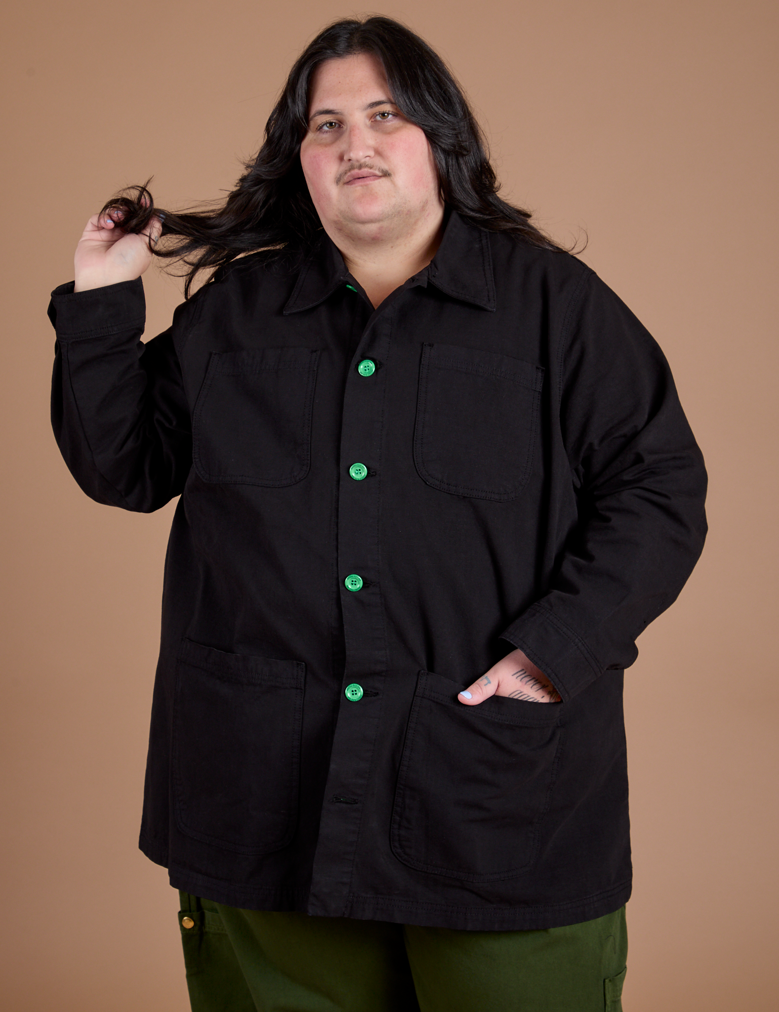 Sam is wearing a buttoned up Ripstop Field Coat in Basic Black