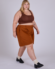 Angled front view of Pleated Trouser Shorts in Burnt Terracotta and fudgesicle brown Mini Tank on Juliet