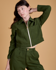 Alex is wearing a zipped up Heritage Mechanic Jacket in Evergreen