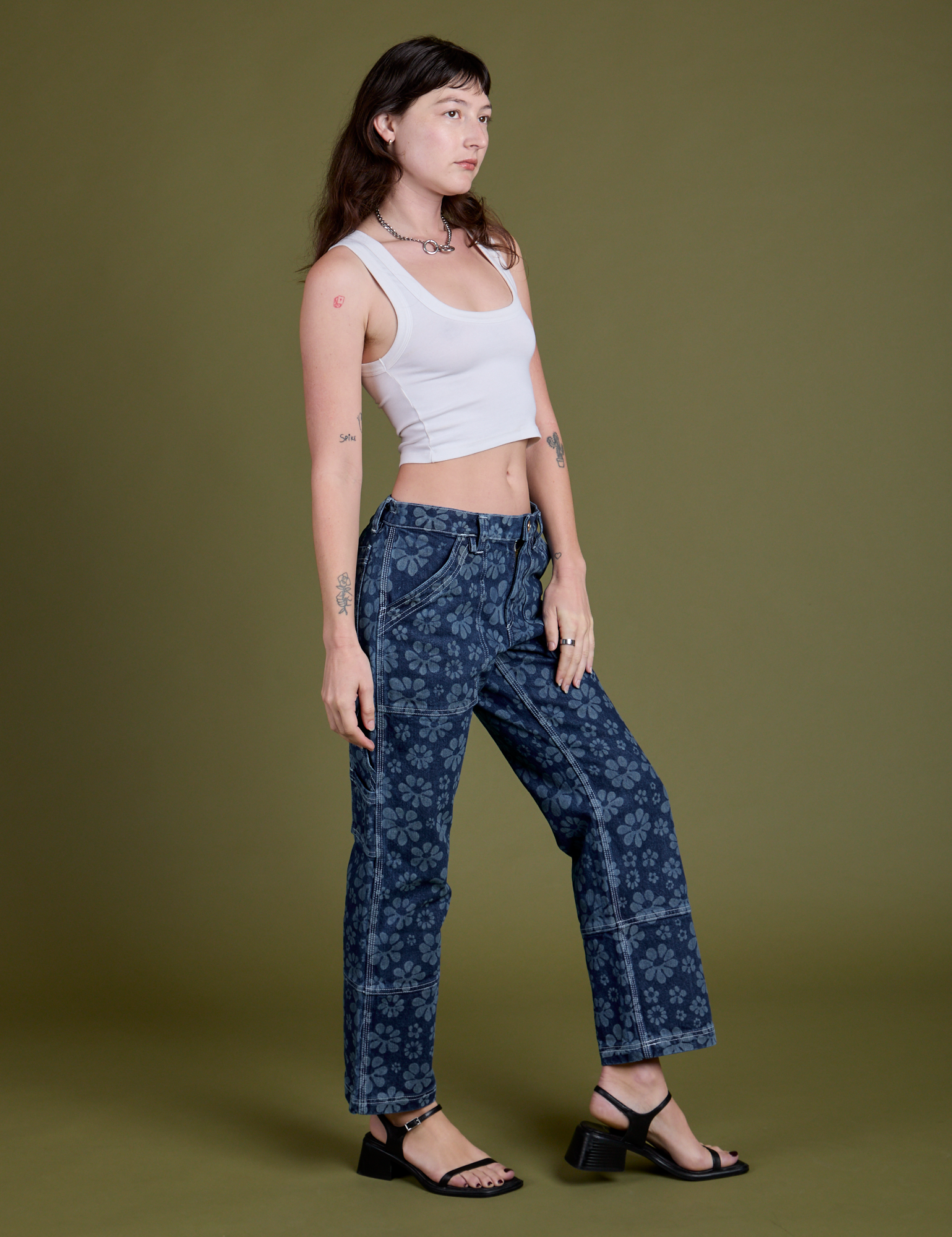 Angled front view of Lazy Daisy Mid-Rise Carpenter Jeans and Cropped Tank in vintage tee white on Alex