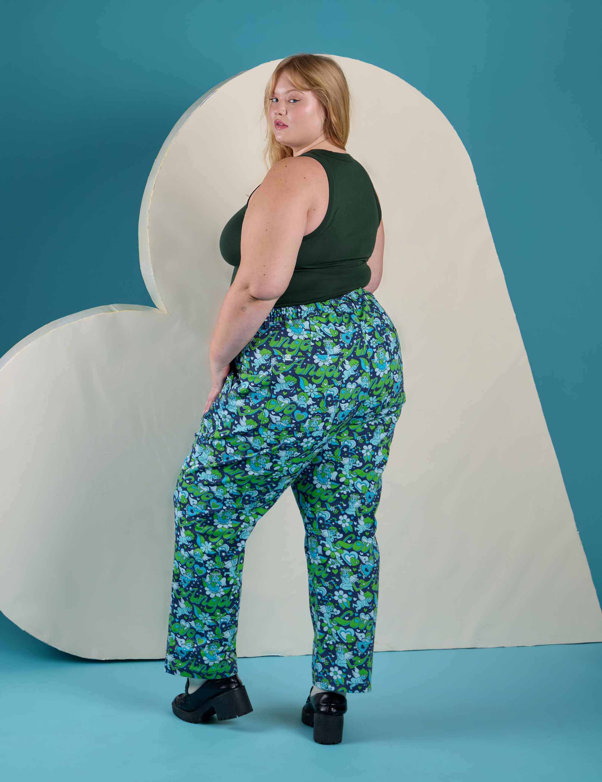 Angled back view of Work Pants in Angel Print and swamp green Cropped Tank on Juliet