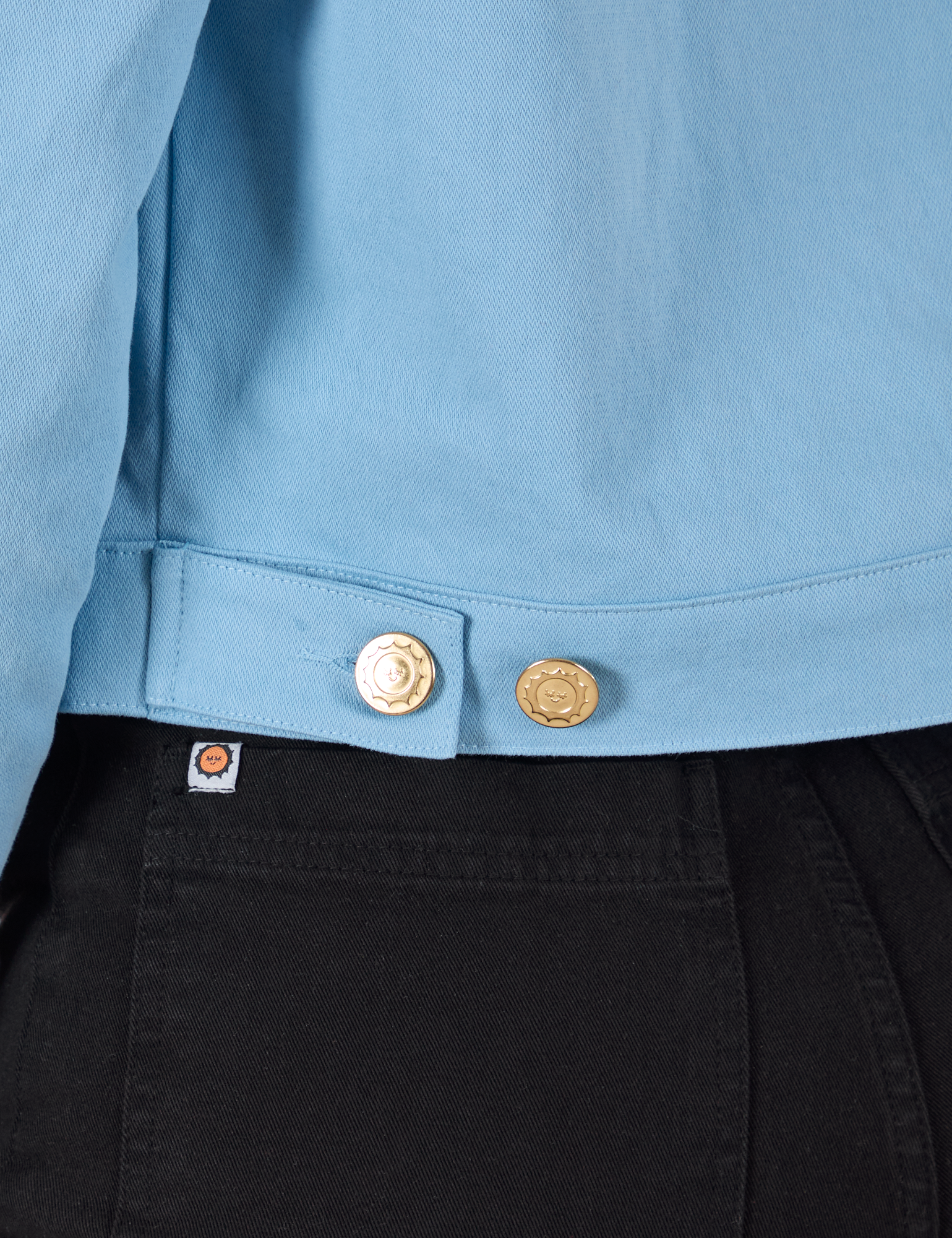 Close up of custom brass buttons on Mechanic Jacket in Baby Blue