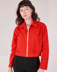 Alex is wearing a zipped up Mechanic Jacket in Mustang Red