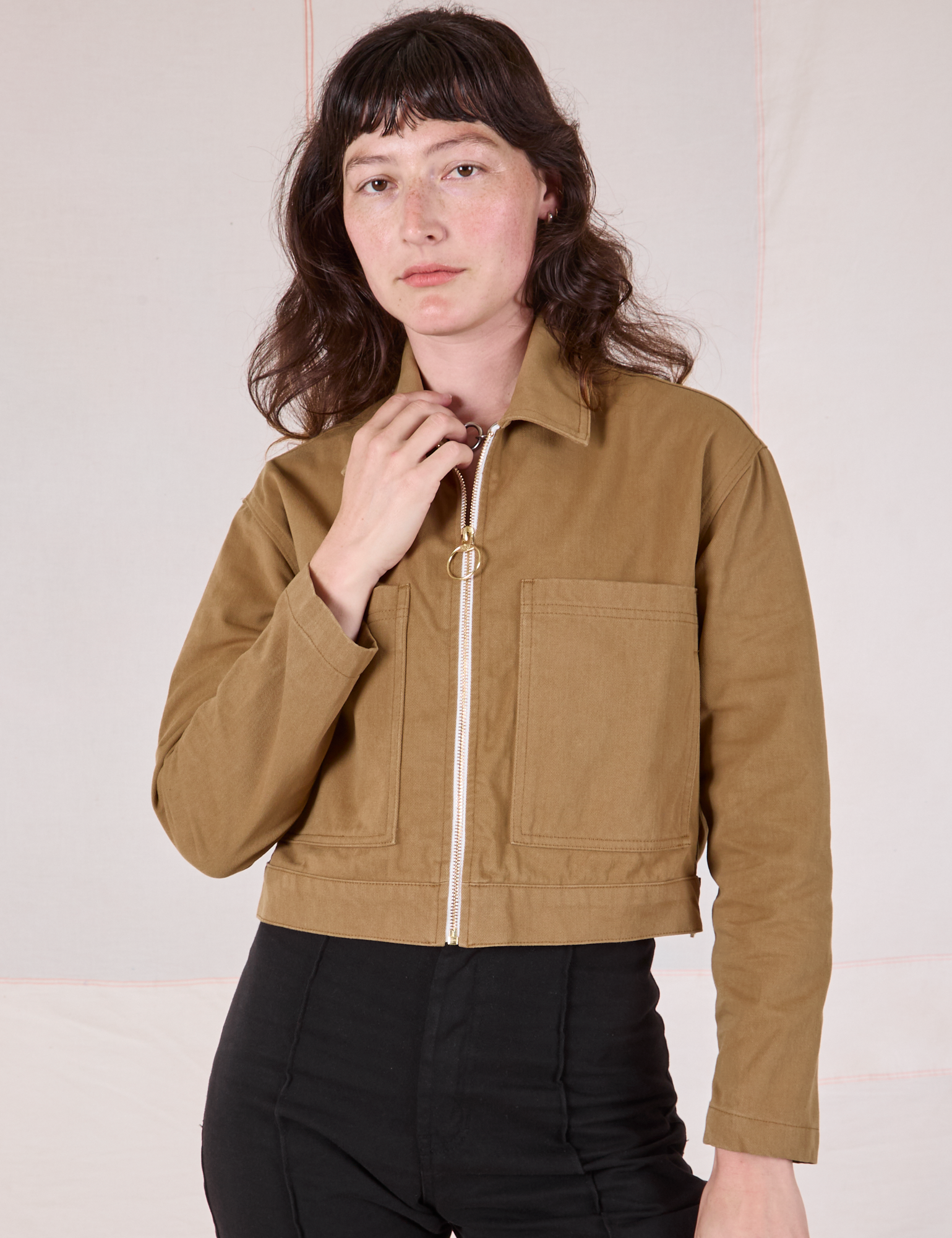 Alex is wearing a zipped up Mechanic Jacket in Desert Brown