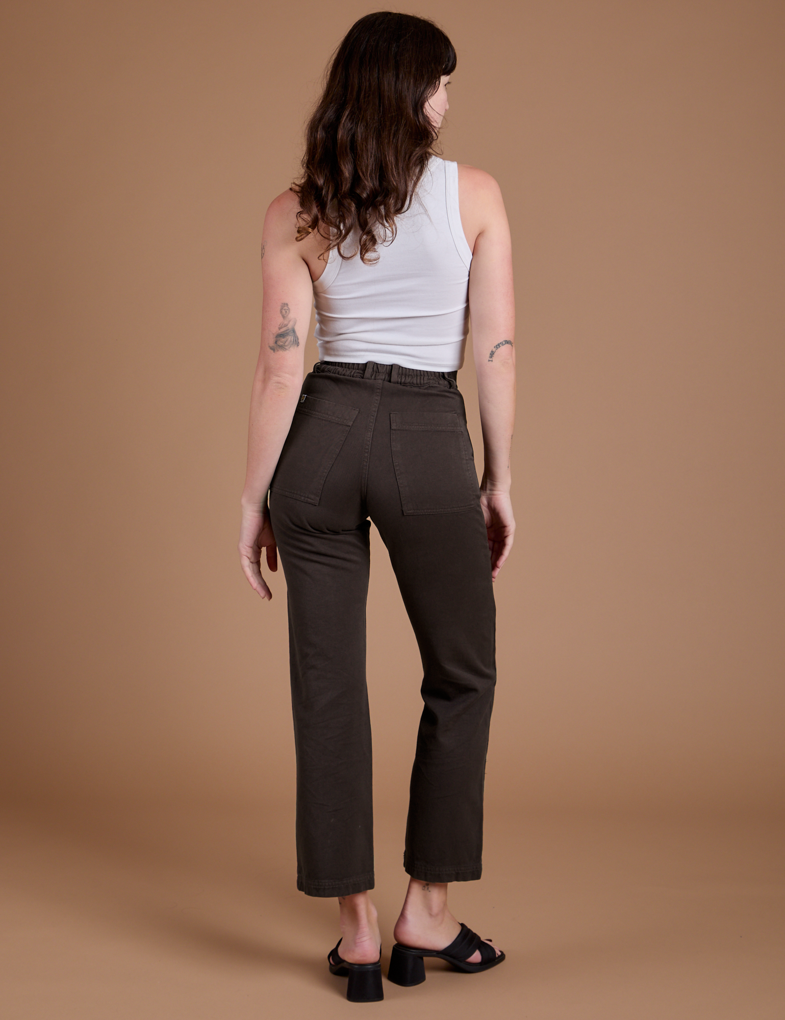 Back view of Organic Work Pants in Espresso Brown and vintage tee white Cropped Tank on Alex