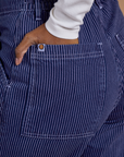 Close up of Kandia's hand in the back pocket of Railroad Denim Work Pants in Faded Grape Overdye