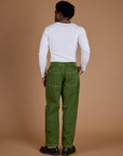 Back view of Railroad Denim Work Pants in Gross Green Overdye and vintage tee white long sleeve baby tee