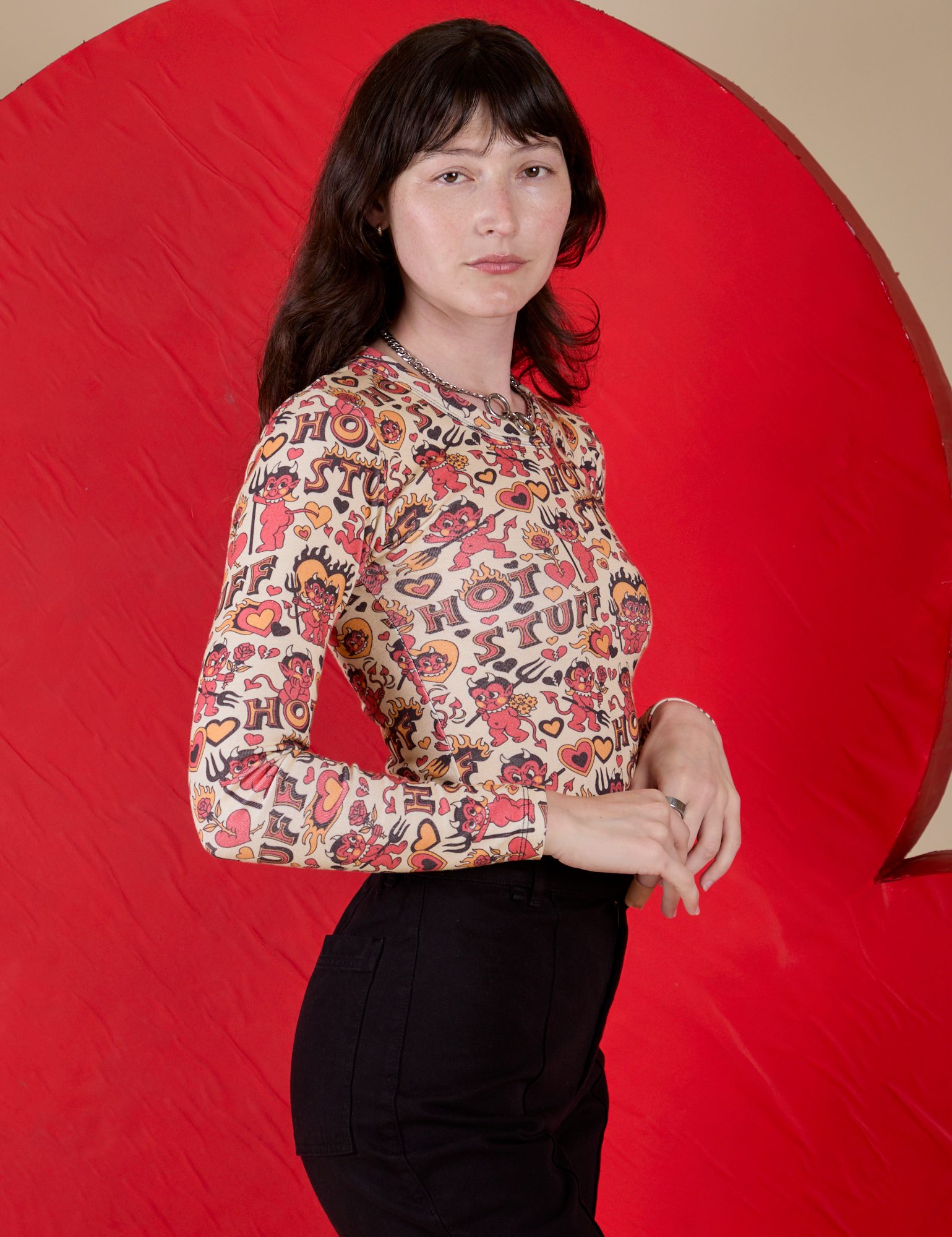 Side view of Long Sleeve Baby Tee in Hot Stuff Print on Alex