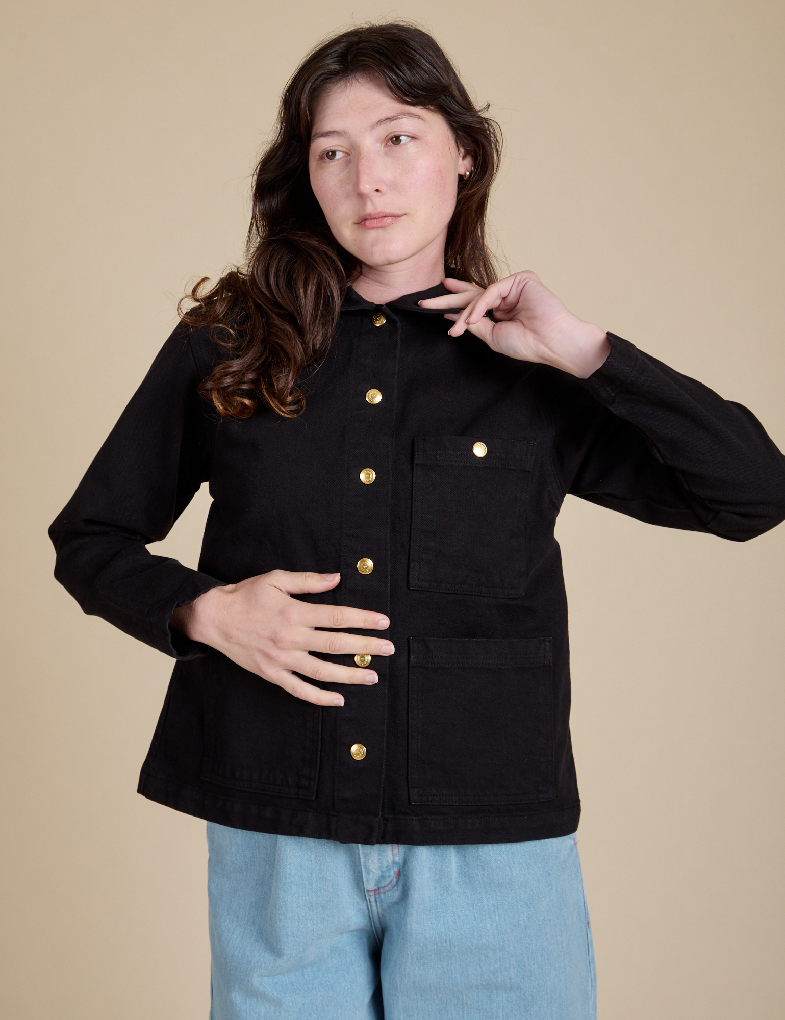 Alex is wearing a buttoned up Work Jacket in Basic Black