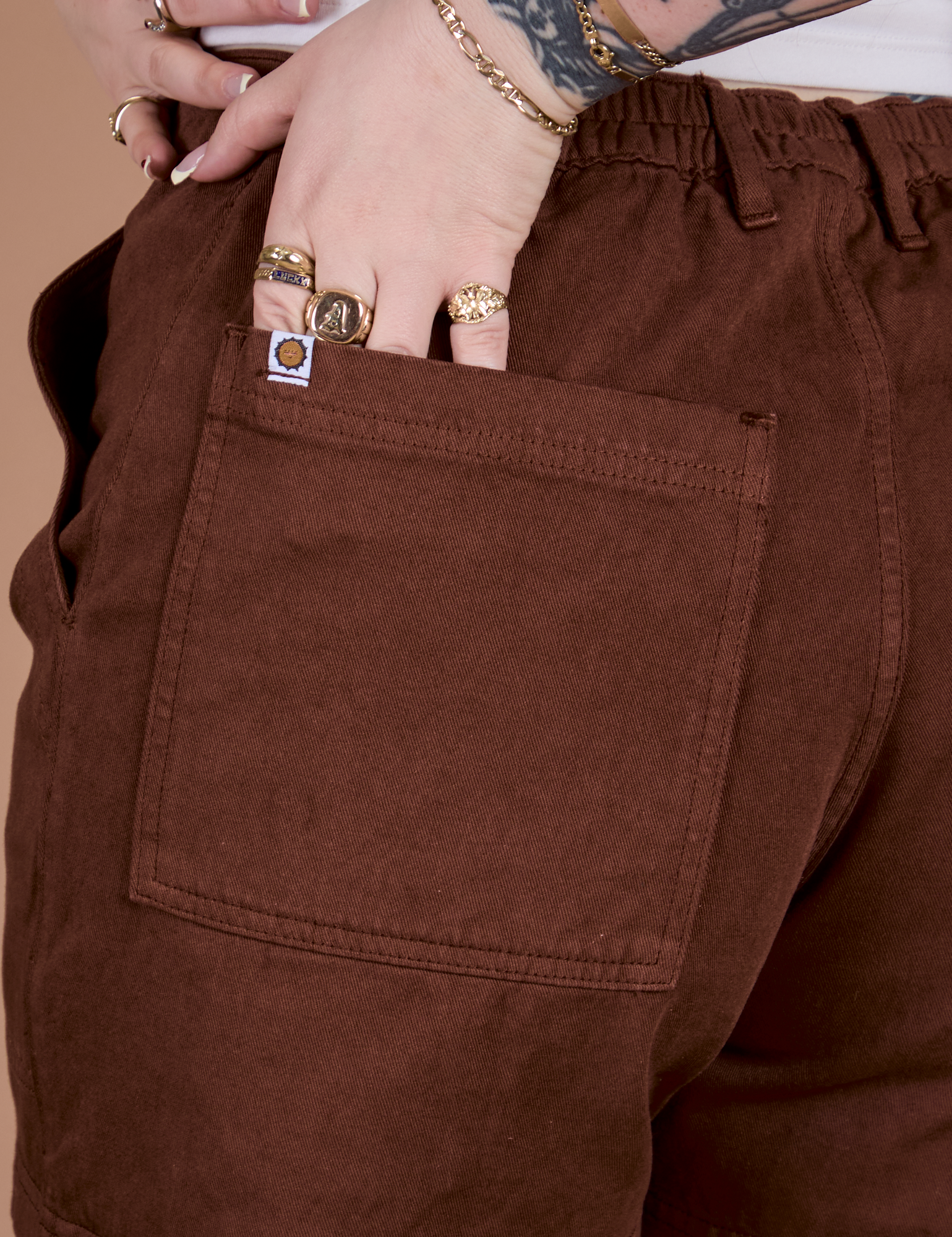 Close up of Sydney's hand in the back pocket of Classic Work Shorts in Fudgesicle Brown