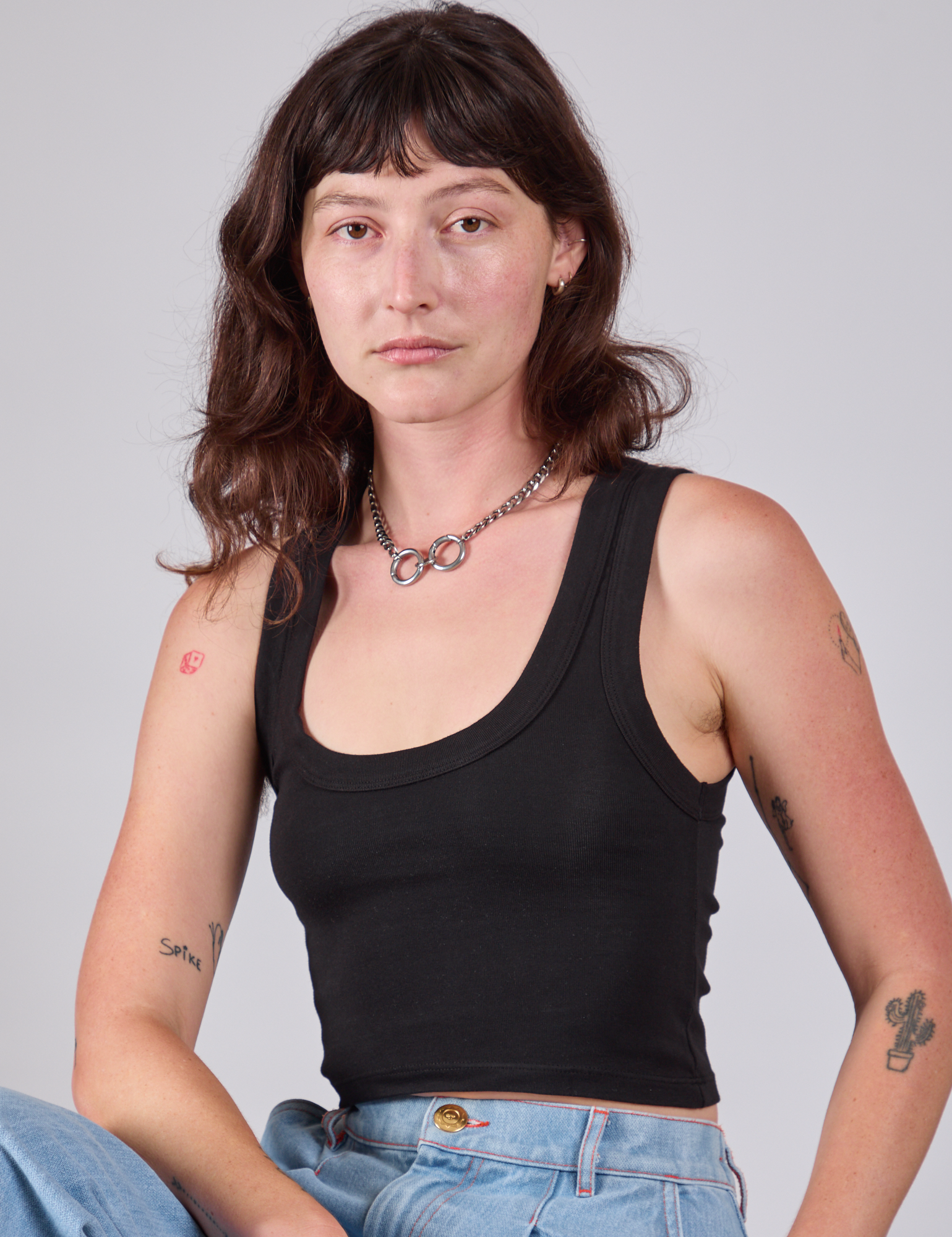 Alex is 5'8" and wearing P Cropped Tank Top in Basic Black