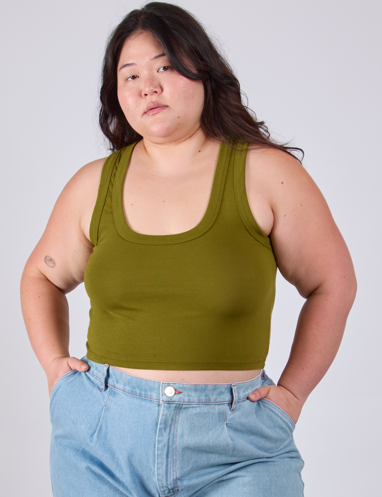 Ashley is 5'7" and wearing L Cropped Tank Top in Olive Green