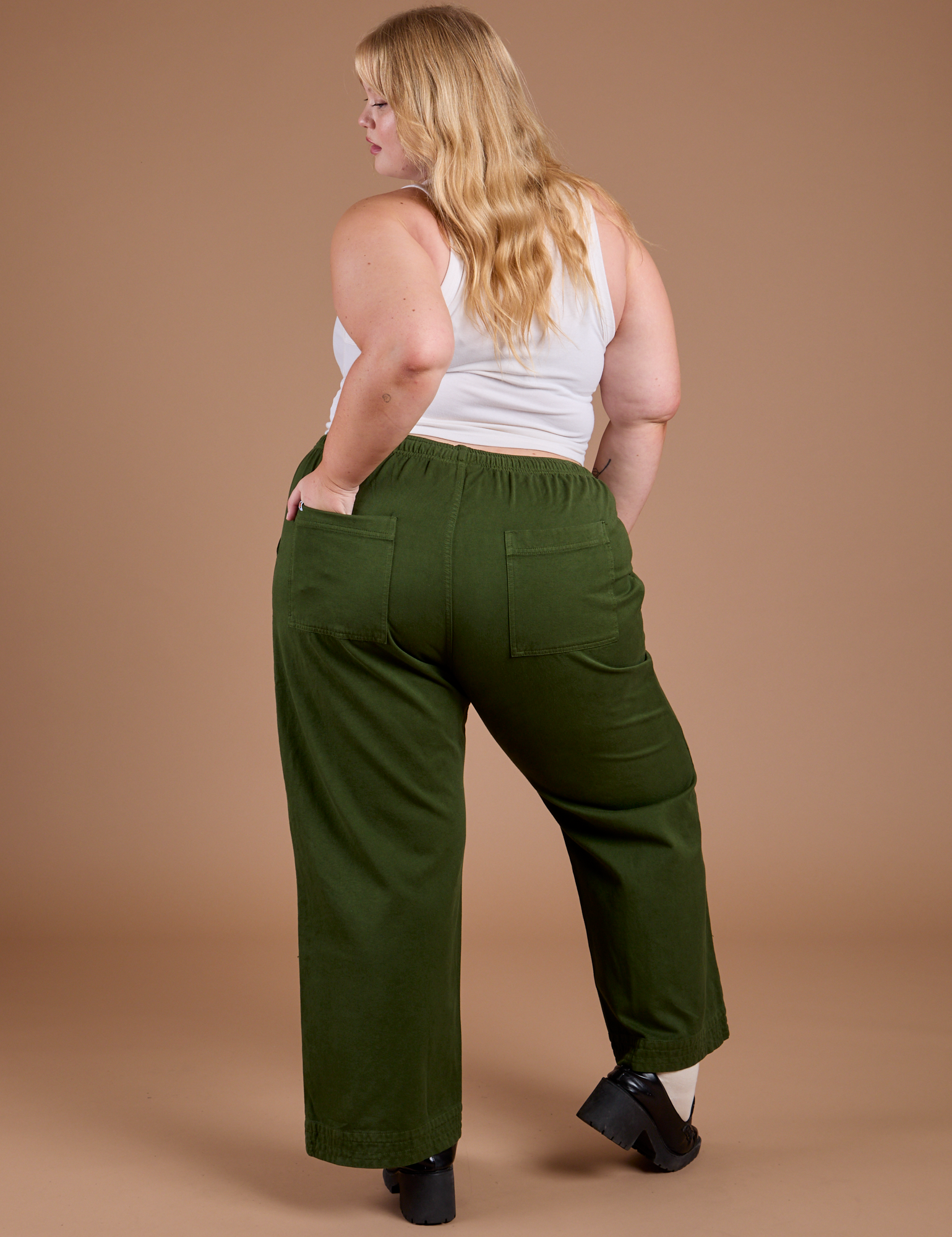 Back view of Organic Action Pants in Evergreen and vintage tee white Cropped Tank on Juliet