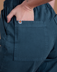 Close up of Alex's hand in the back pocket of Action Pants in Lagoon