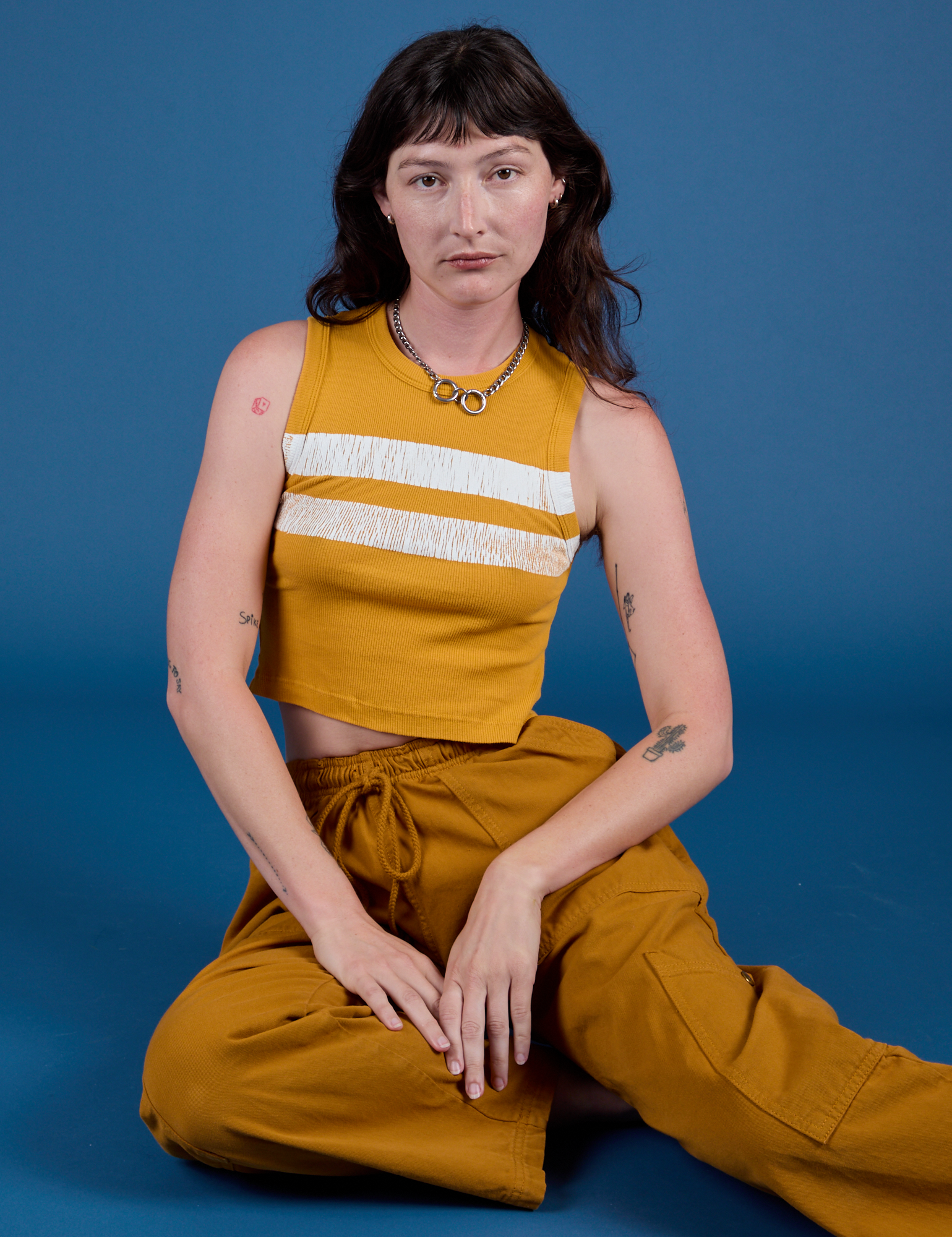 Alex is wearing Painted Muscle Tee in Mustard Yellow and spicy mustard Drop Pocket Cargo Pants