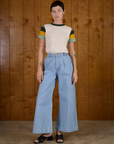 Alex is wearing Calypso Tee in Off White Multi tucked into light wash Denim Wide Leg Trousers