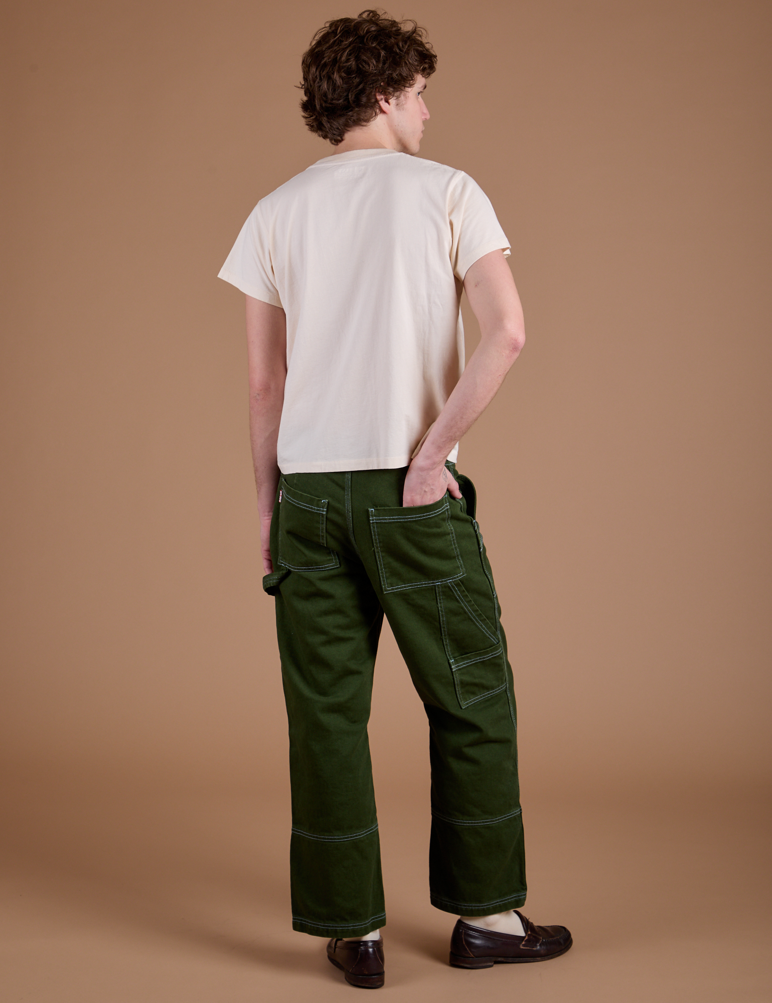 Back view of Carpenter Jeans in Evergreen and the Organic Vintage Tee in Vintage Tee Off-White on Quinn