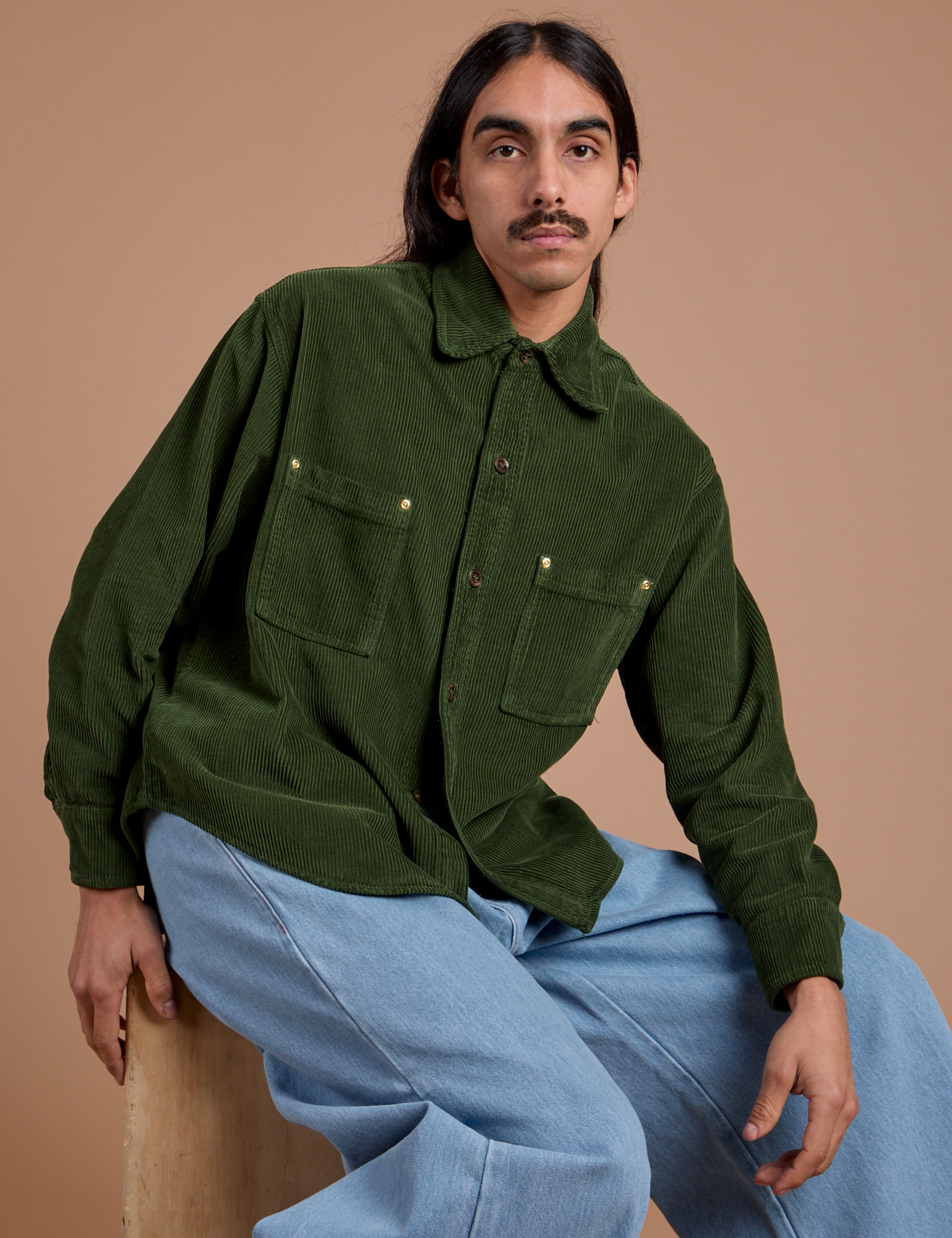Anthony is wearing a buttoned up Cropped Corduroy Overshirt in Evergreen