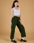 Angled front view of Corduroy Drop Pocket Cargo Pants in Evergreen and Cropped Tank in Vintage Tee White on Alex