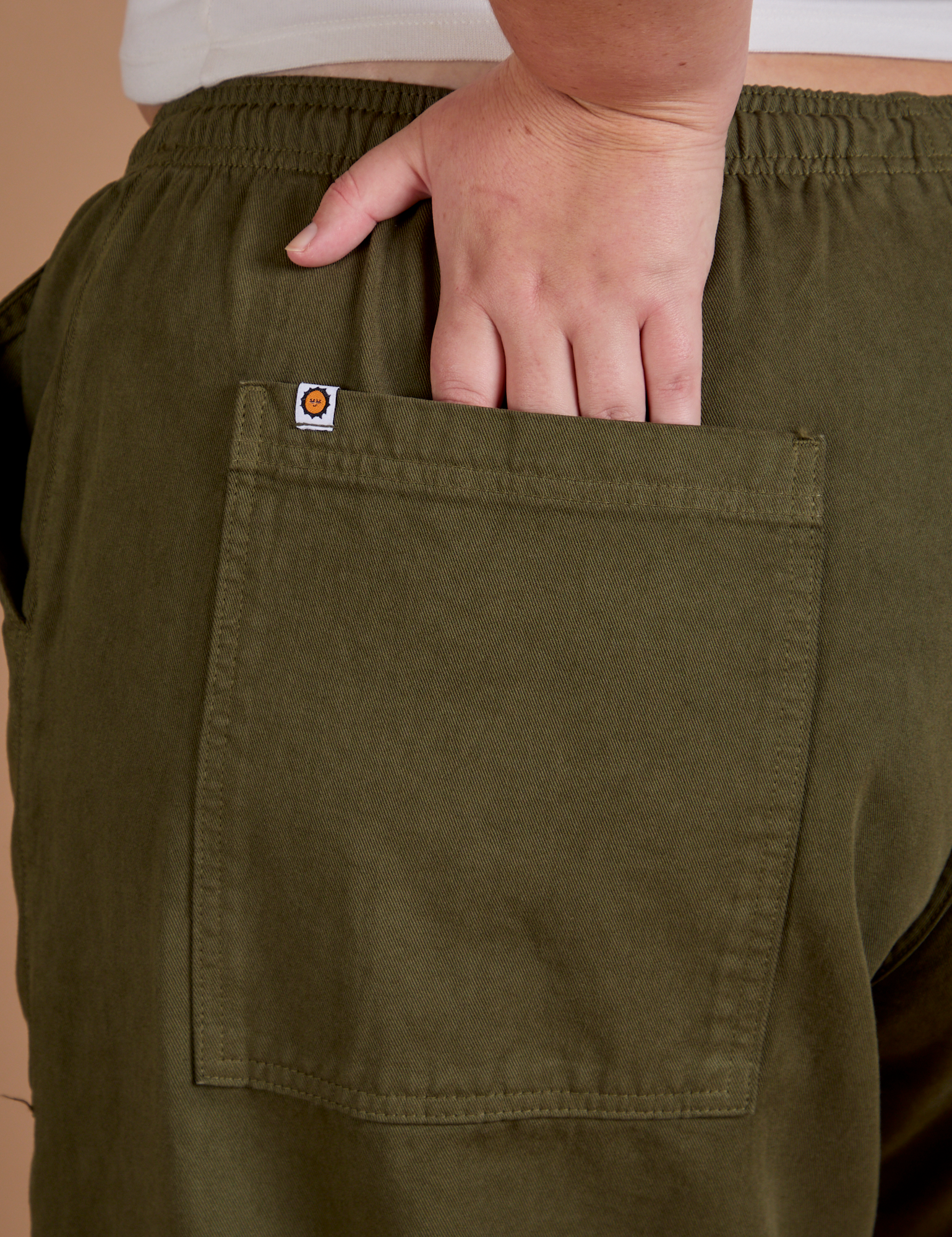 Close up of Juliet's hand in the back pocket of Drop Pocket Cargo Pants in Surplus Green