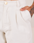 Front close up of Heavyweight Trousers in Vintage Tee Off-White. Jesse has their hand in the pocket.