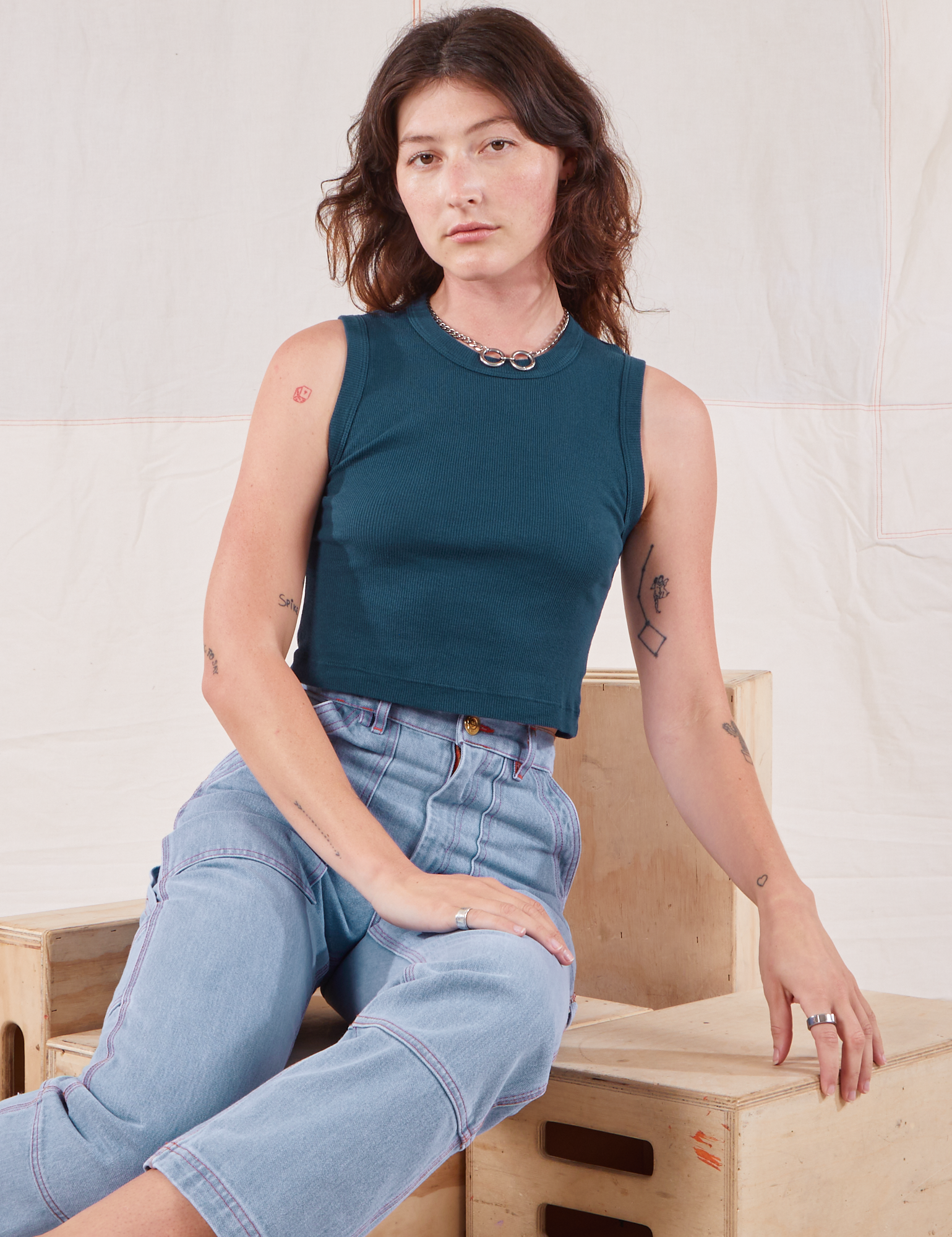 Alex is wearing Muscle Tee in Lagoon and light wash Carpenter Jeans