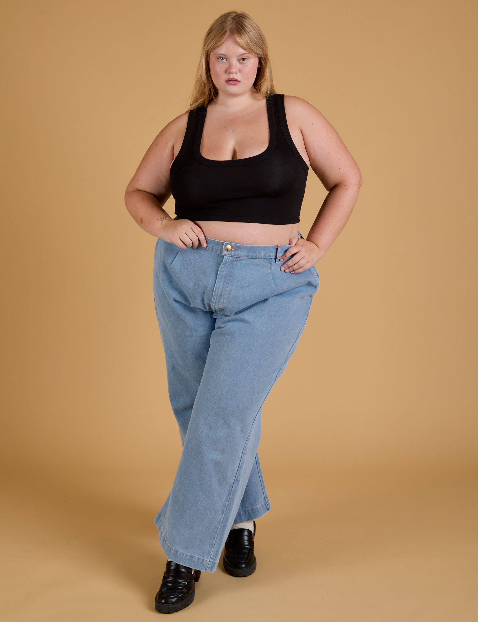 Juliet is wearing Mini Tank in Basic Black and light wash Indigo Wide Leg Trousers