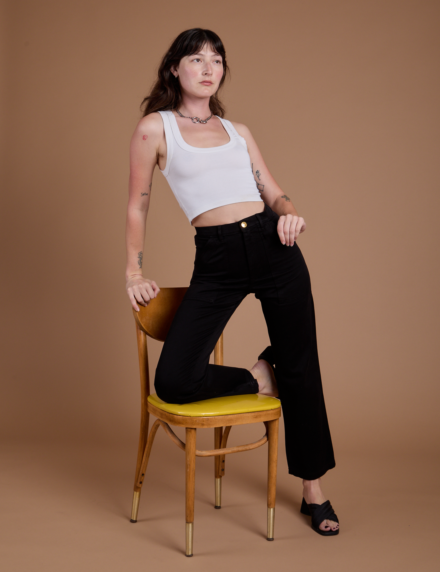 Alex is wearing Organic Work Pants in Basic Black and vintage tee white Cropped Tank