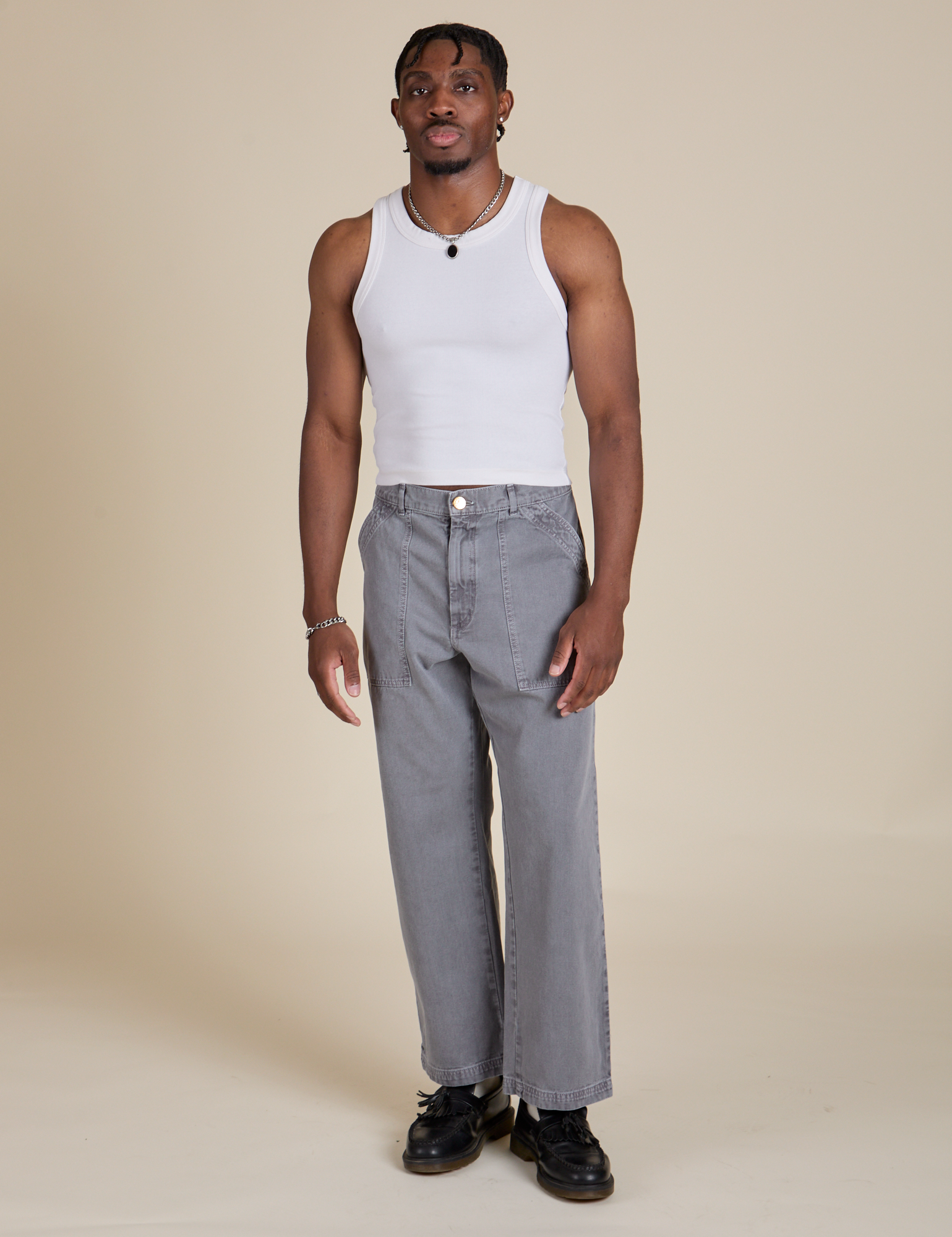 Isaac is 5’10” and wearing S Racerback Tank in Vintage Tee White paired with washed grey Work Pants