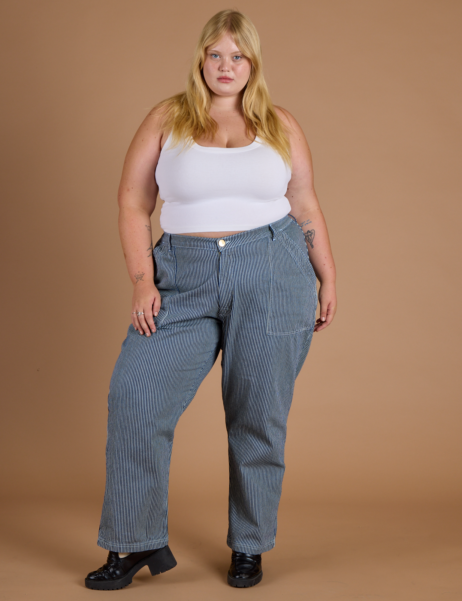 Juliet is 5’7” and wearing 2XL Railroad Denim Work Pants in Natural paired with vintage tee white Cropped Tank