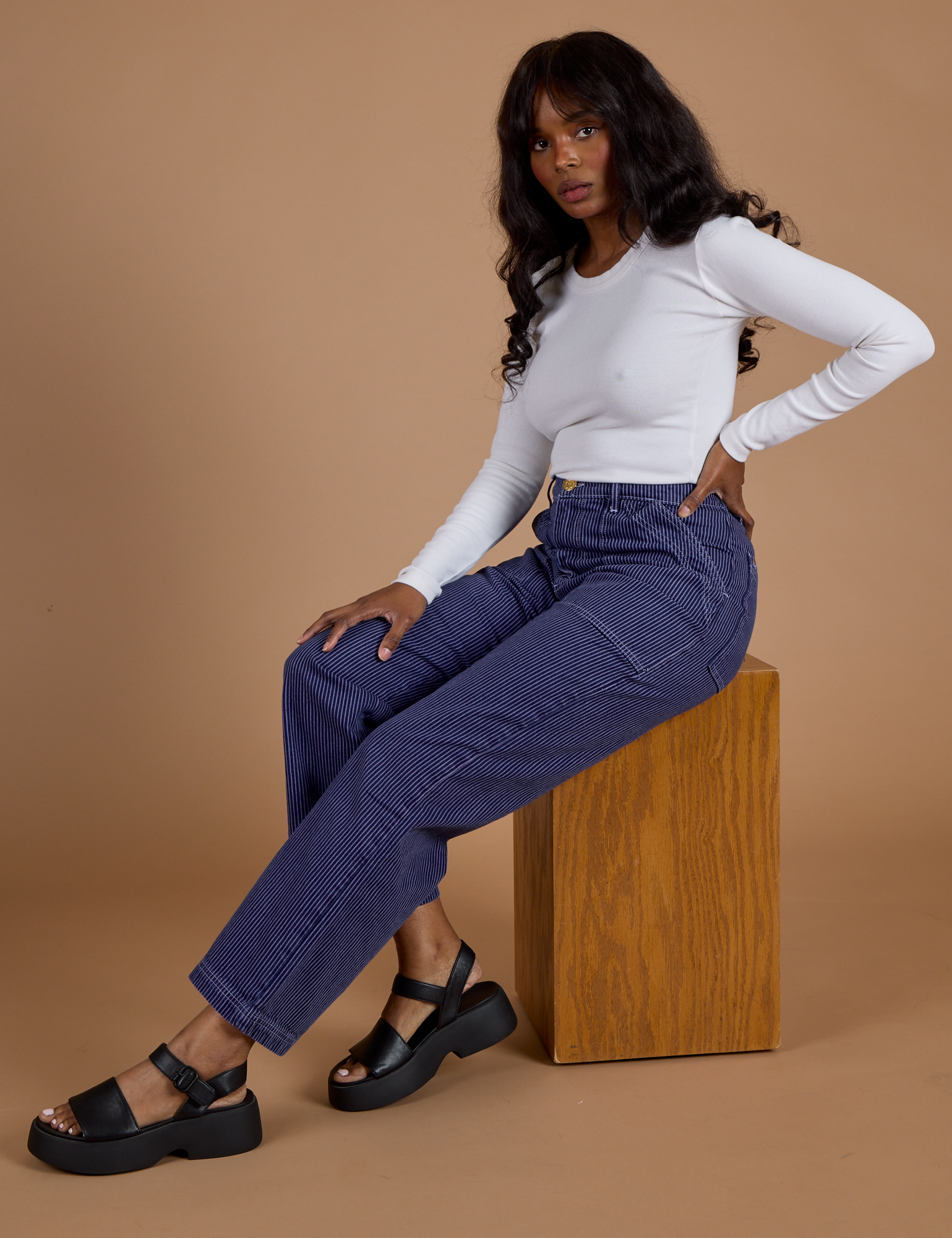 Kandia is wearing Railroad Denim Work Pants in Faded Grape Overdye and Long Sleeve Baby Tee in Vintage Tee White