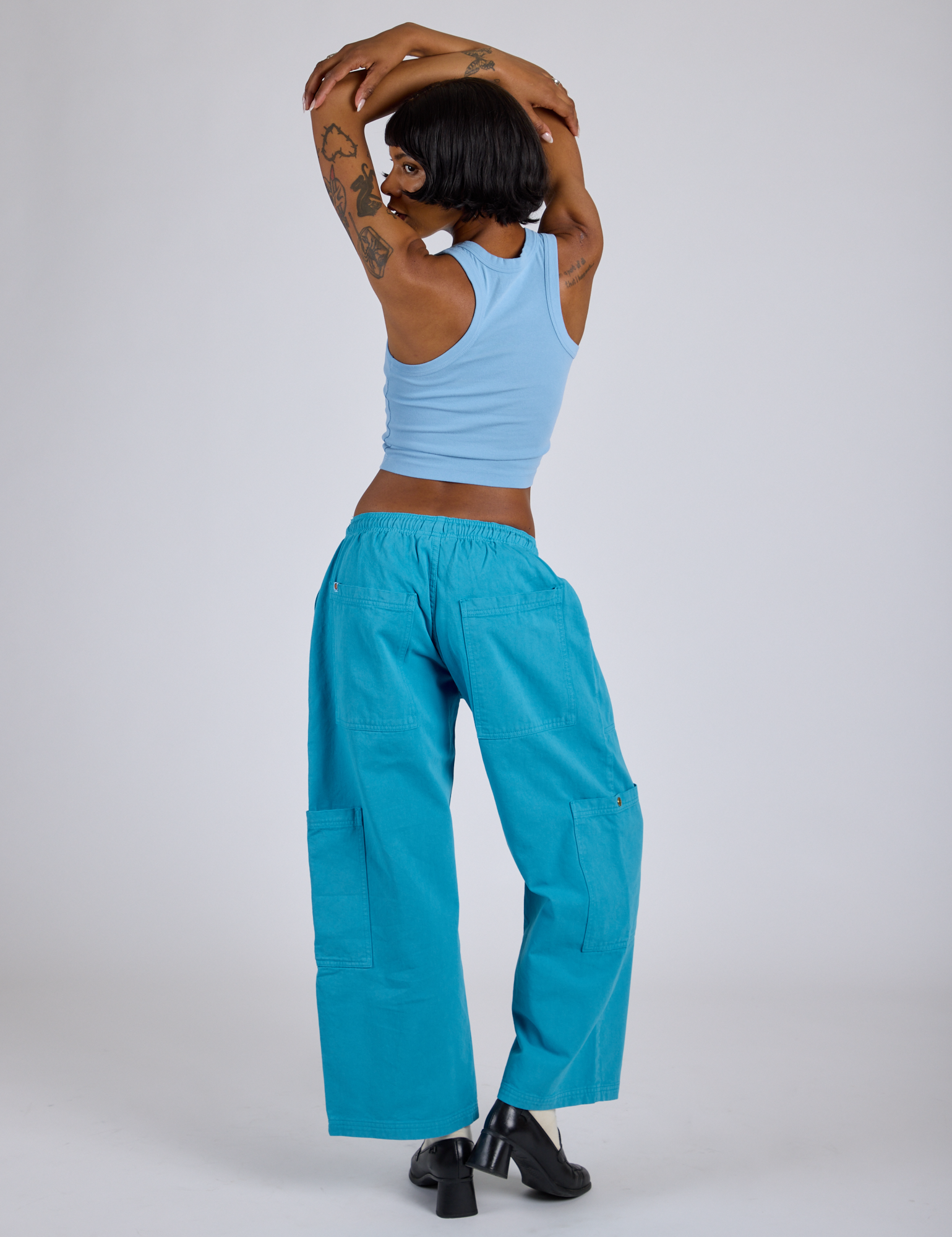 Back view of Drop Pocket Cargo Pants in Hawaiian Blue and baby blue Racerback Tank on Kira