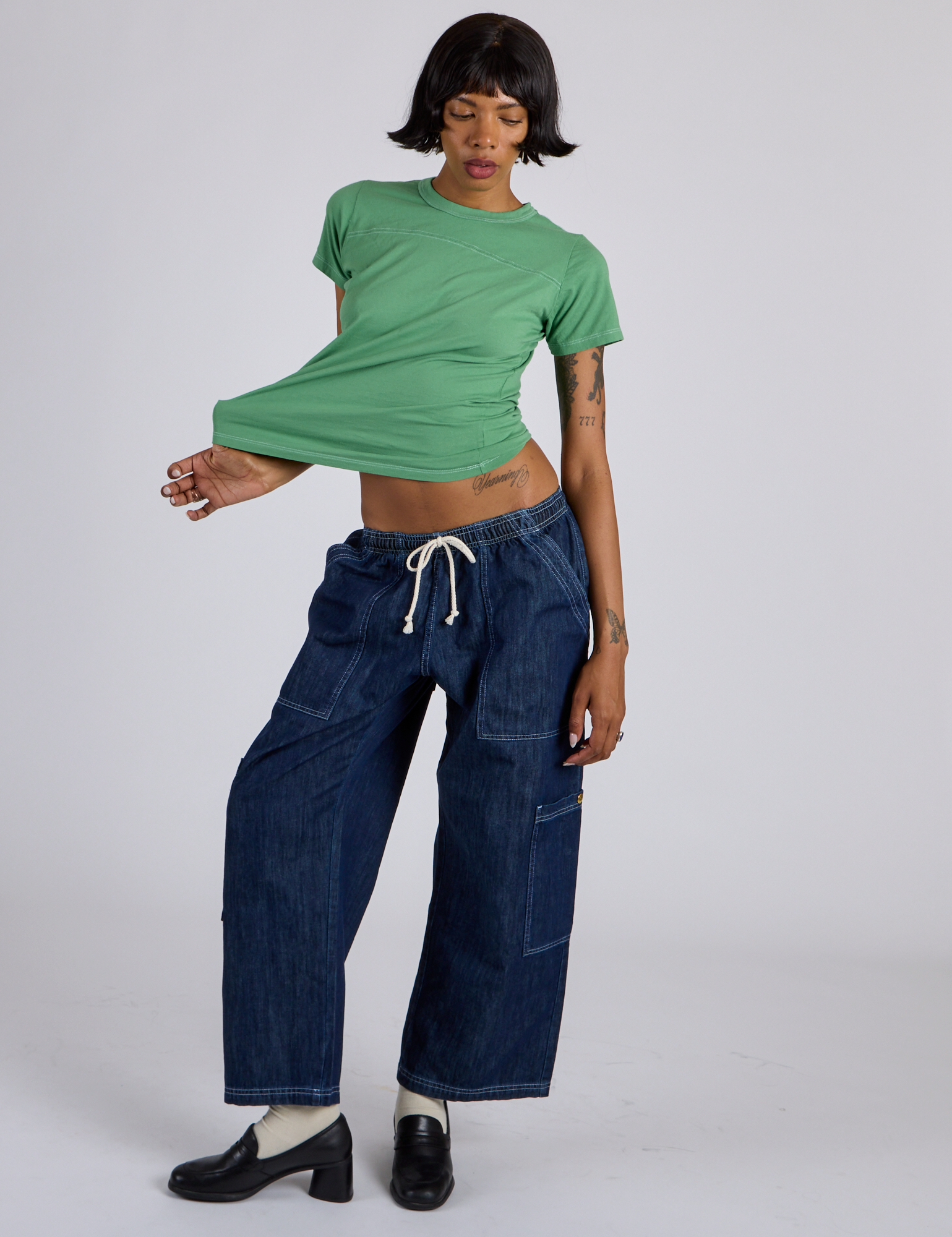 Kira is wearing Jr. Varsity Tee in Seafoam Green and dark wash Denim Drop Pocket Pants